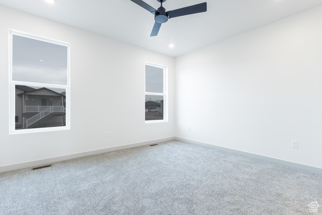 Carpeted empty room with recessed lighting, visible vents, baseboards, and ceiling fan