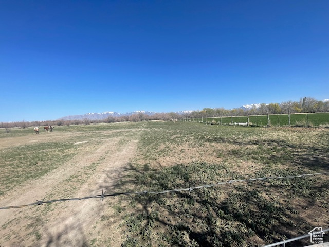 View of yard featuring a rural view and fence