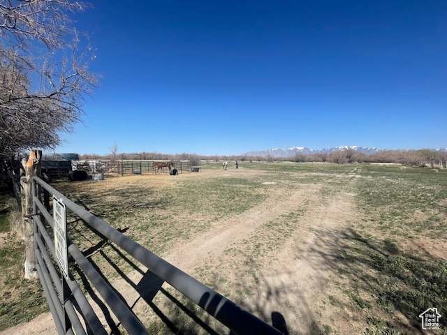 View of yard featuring a rural view, fence, and a mountain view