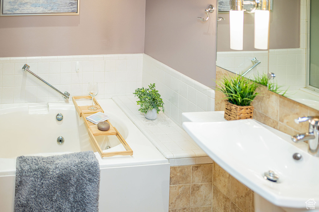 Bathroom featuring a jetted tub and a sink