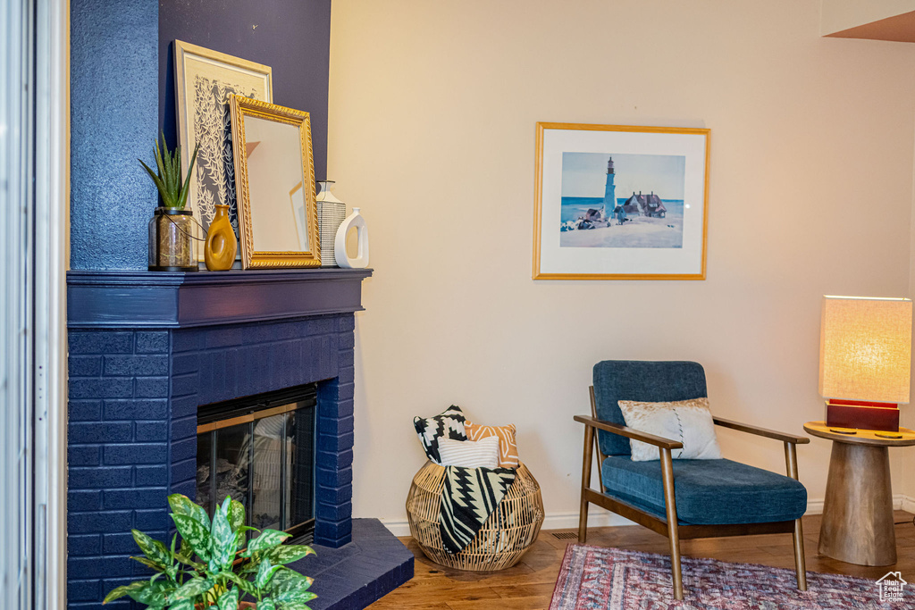 Living area featuring a brick fireplace and wood finished floors