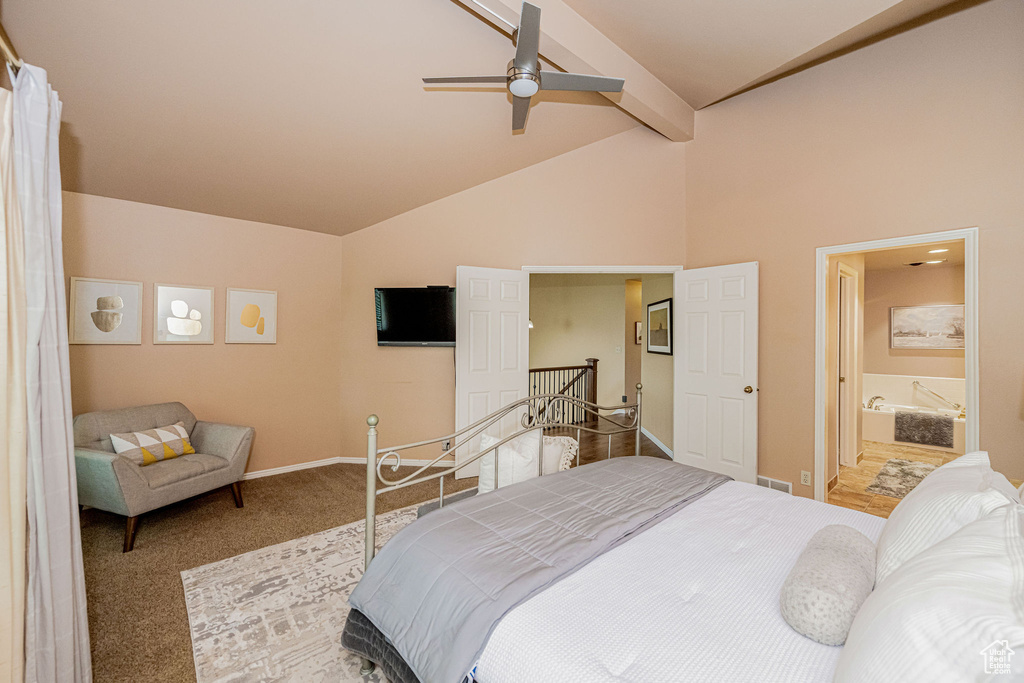 Bedroom with carpet floors, beamed ceiling, high vaulted ceiling, connected bathroom, and a ceiling fan