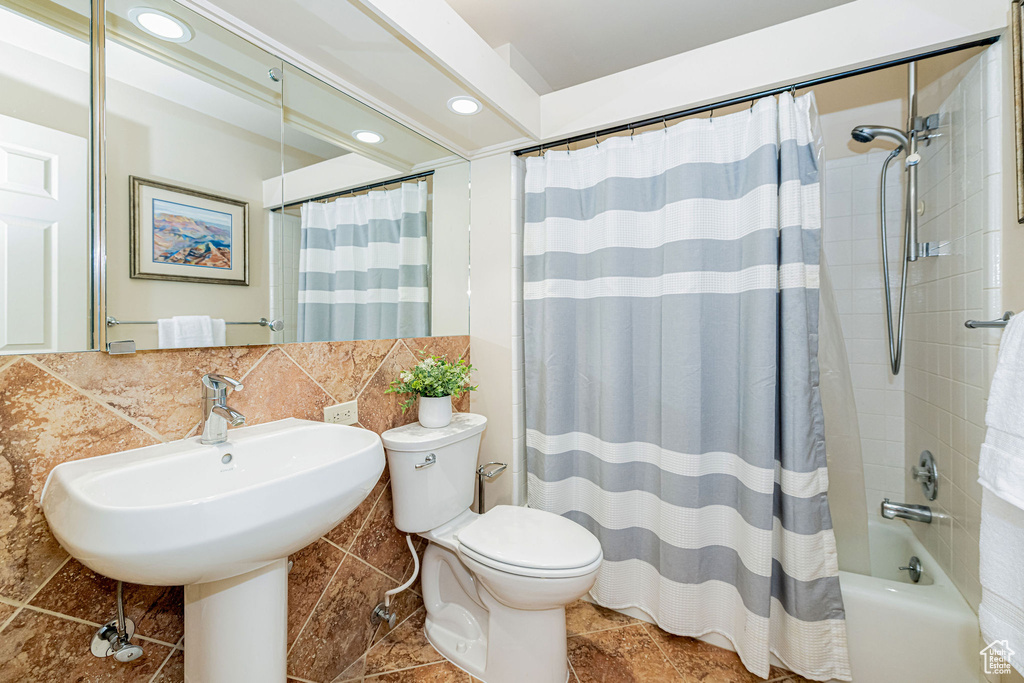 Bathroom featuring shower / bath combination with curtain, recessed lighting, and backsplash