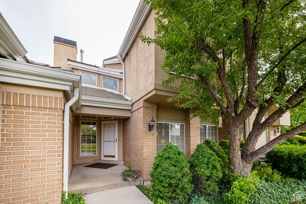 View of exterior entry with brick siding and stucco siding
