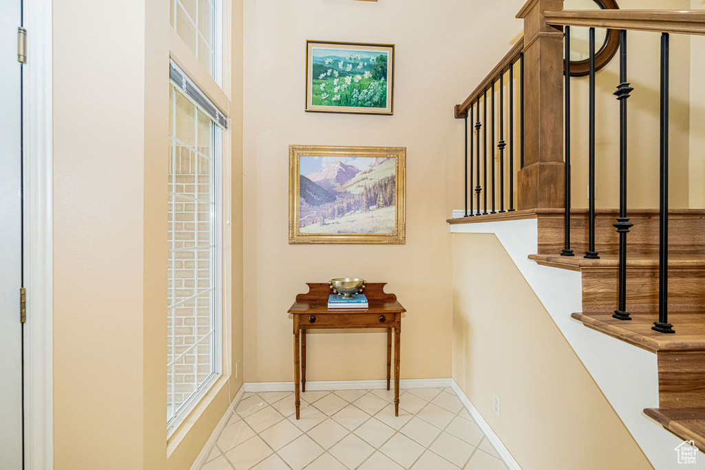 Stairway with baseboards and tile patterned floors