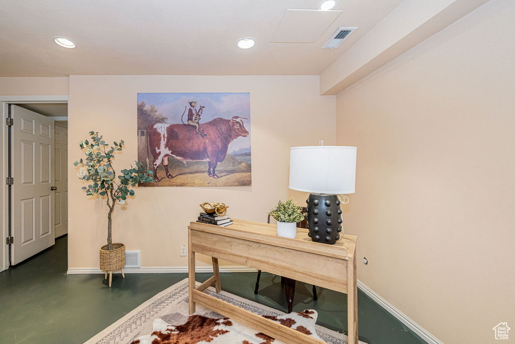 Home office with finished concrete floors and recessed lighting