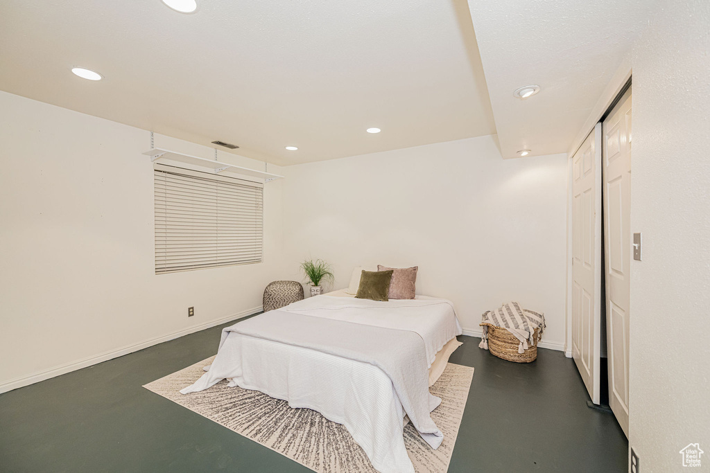Bedroom featuring concrete flooring and recessed lighting