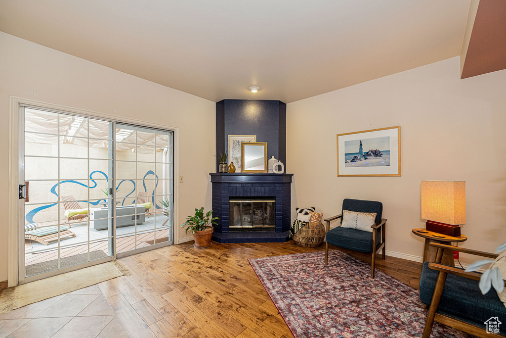 Sitting room with wood finished floors and a fireplace