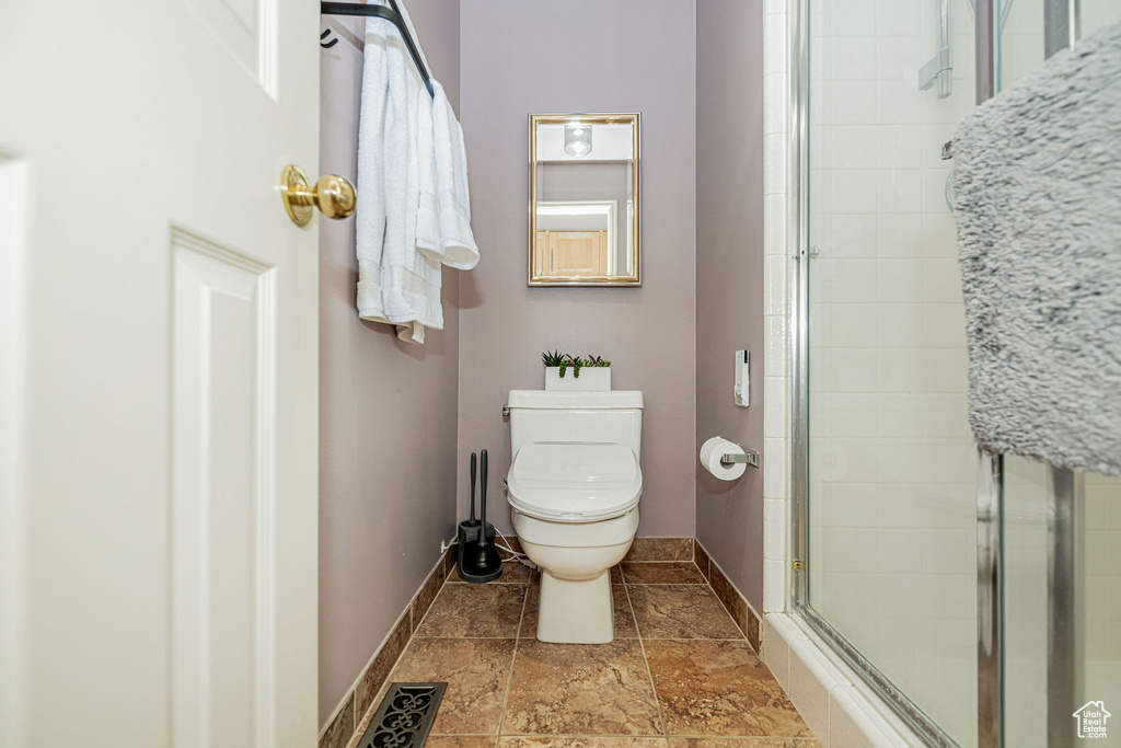 Full bathroom featuring toilet and a shower stall