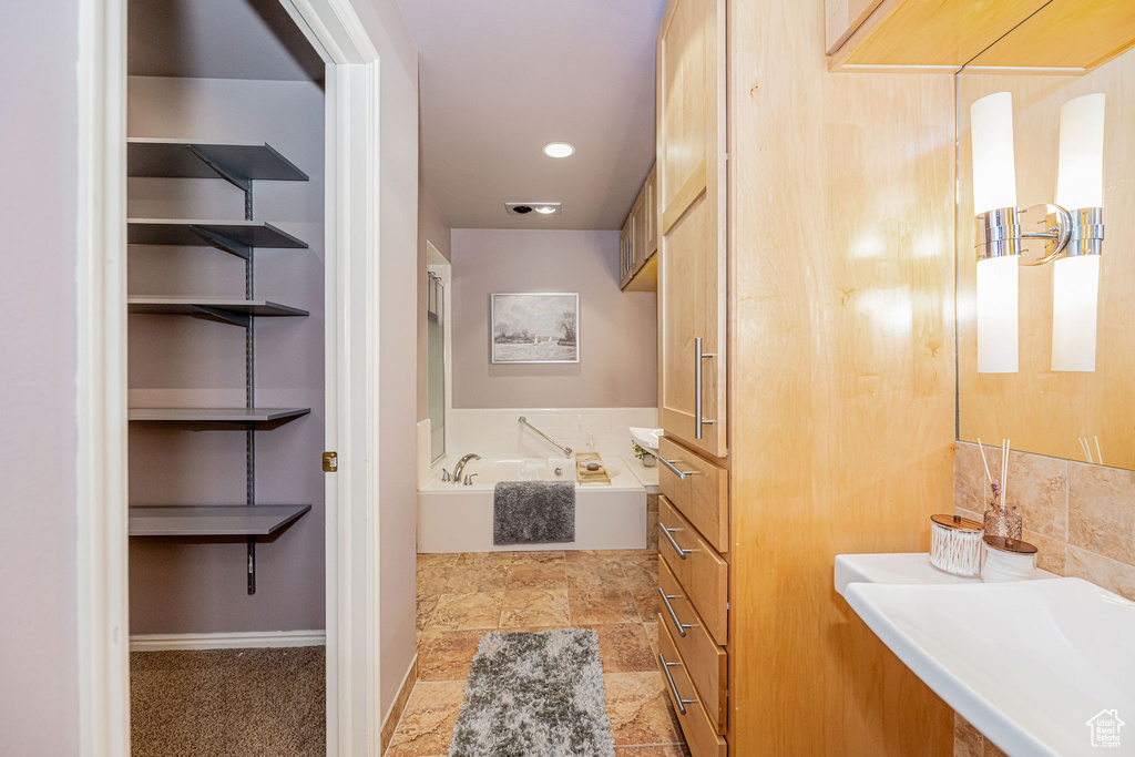 Full bath with a bath and stone finish floors