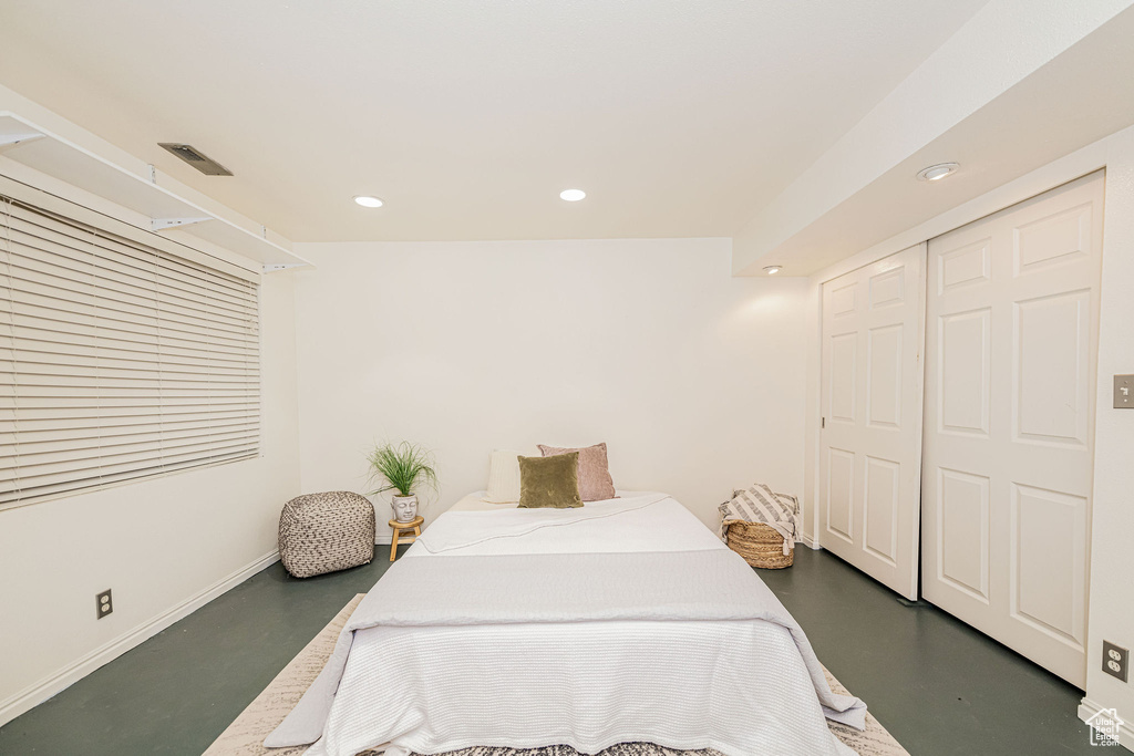Bedroom with concrete floors, a closet, and recessed lighting