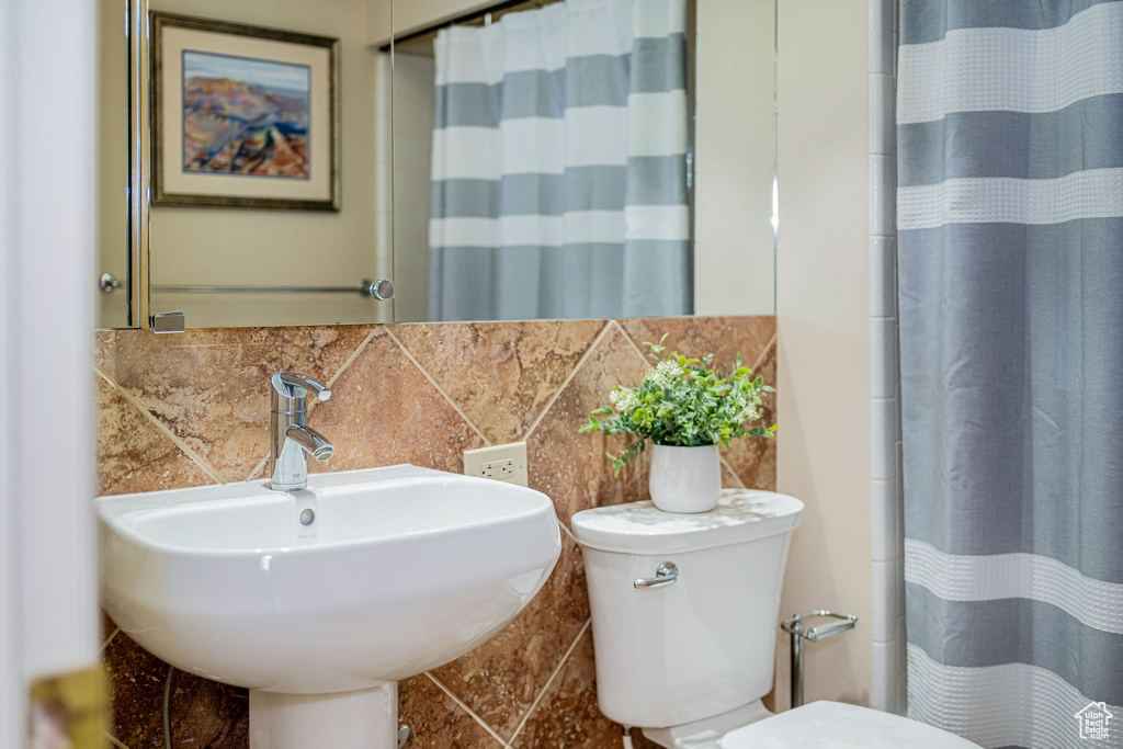 Bathroom featuring backsplash and a shower with curtain