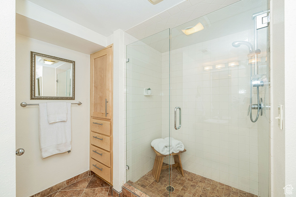 Bathroom with a shower stall and baseboards