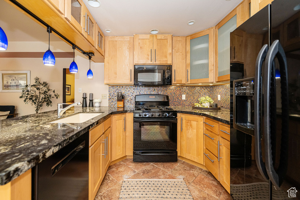 Kitchen featuring black appliances, backsplash, a peninsula, dark stone countertops, and recessed lighting