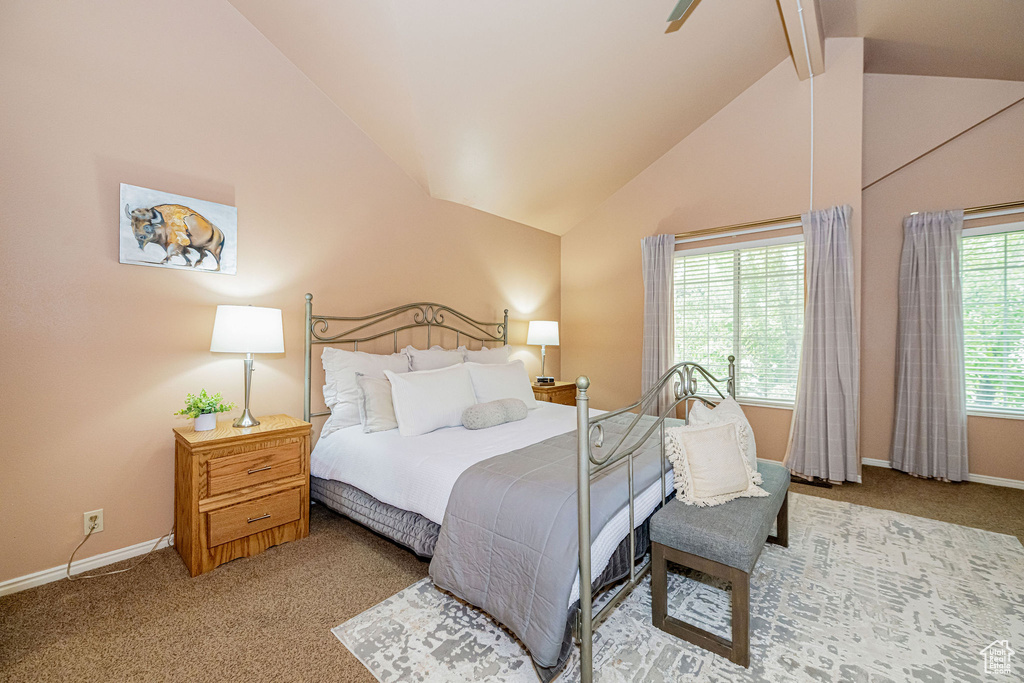 Carpeted bedroom featuring beam ceiling and high vaulted ceiling