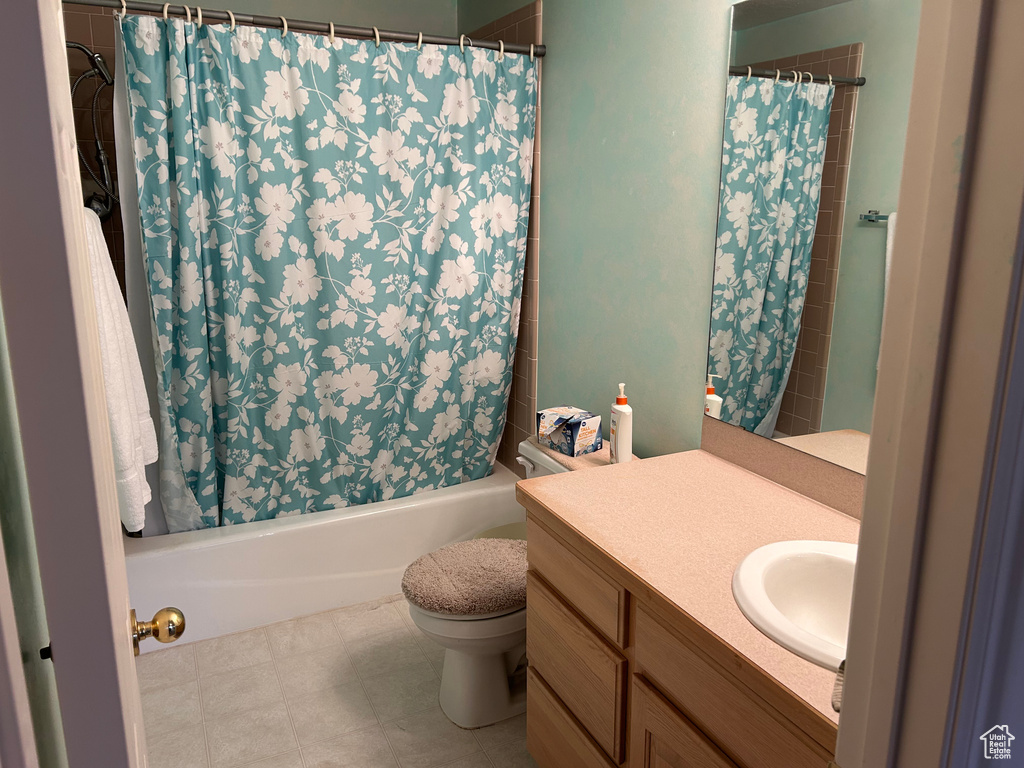 Bathroom with toilet, shower / bath combo with shower curtain, and vanity