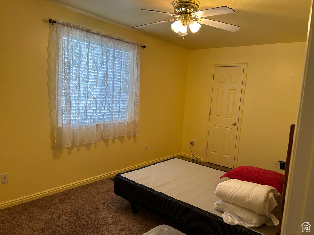 Carpeted bedroom with baseboards and a ceiling fan
