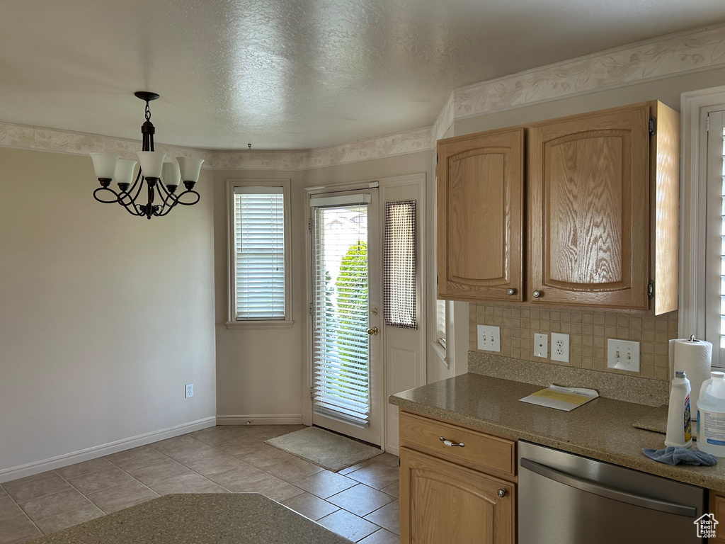 Kitchen featuring a notable chandelier, baseboards, decorative light fixtures, decorative backsplash, and dishwasher