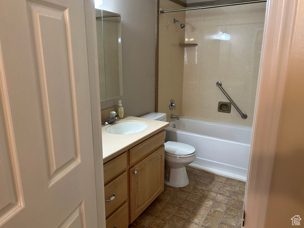Bathroom with toilet, vanity, and washtub / shower combination