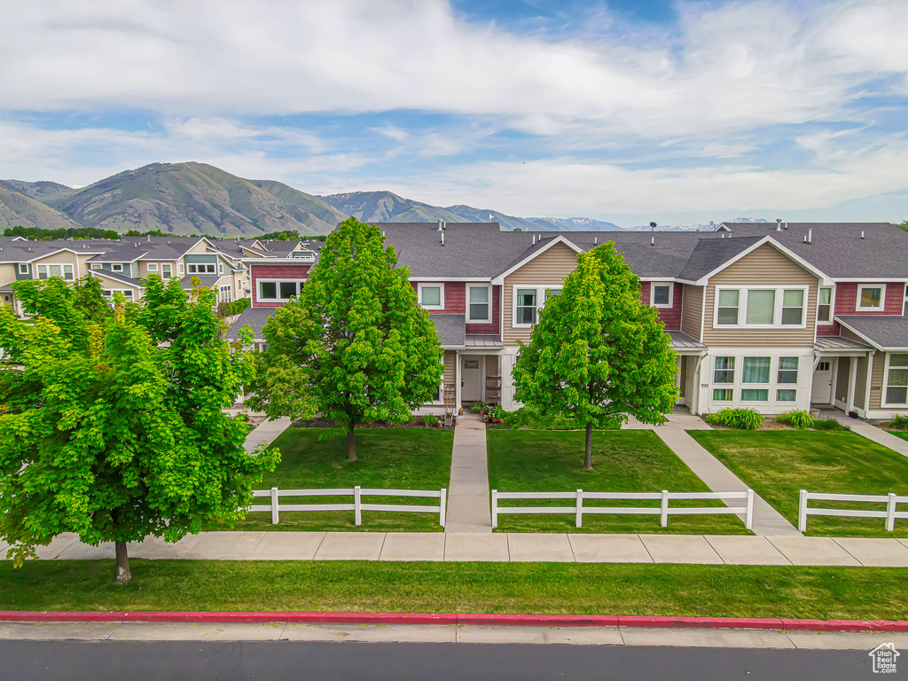 View of front of home with a residential view, a mountain view, and a shingled roof