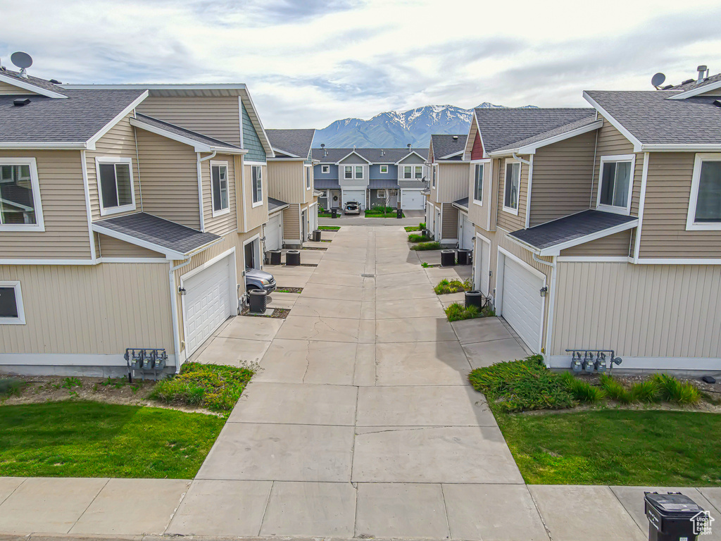 Surrounding community featuring a residential view, an attached garage, a mountain view, and driveway