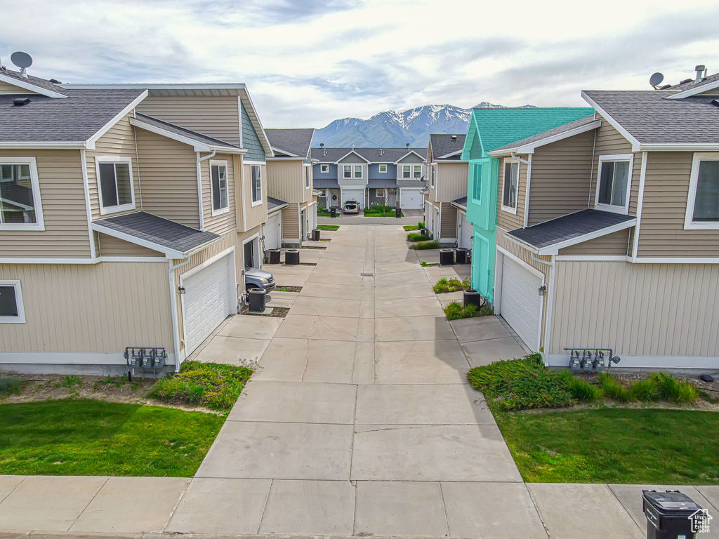View of property's community featuring a residential view, an attached garage, a mountain view, and concrete driveway