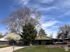 View of front of house featuring concrete driveway, a fenced front yard, and a front yard