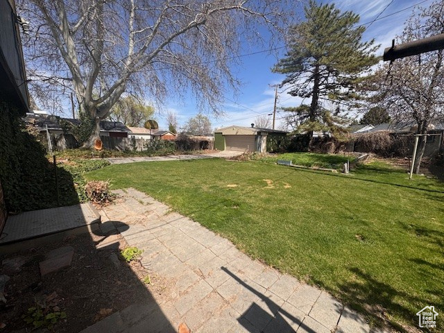 View of yard with fence and an outbuilding