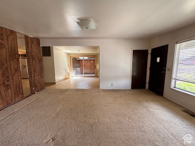 Carpeted empty room featuring visible vents