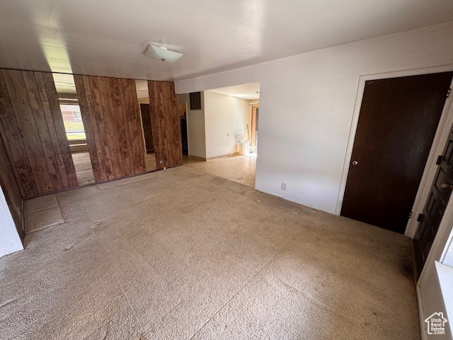 Spare room featuring wooden walls and visible vents