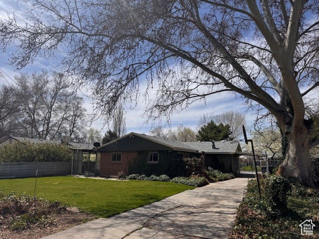 View of home\'s exterior featuring a yard, concrete driveway, and brick siding