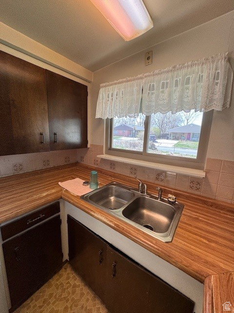 Kitchen with a sink, wood counters, plenty of natural light, and vaulted ceiling