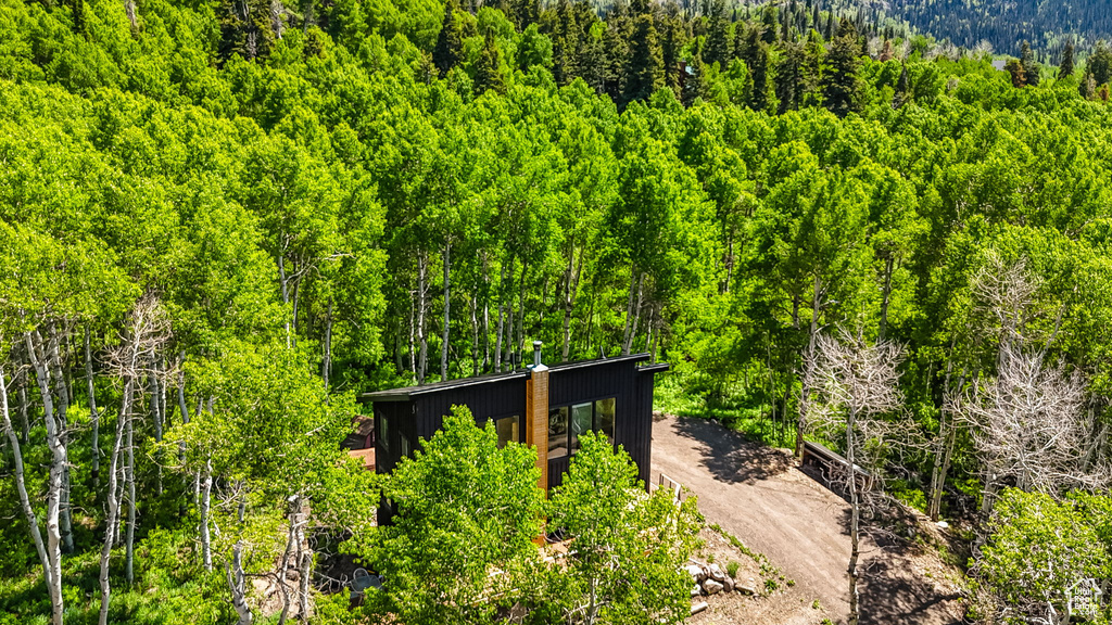 Aerial view of property and surrounding area featuring a forest