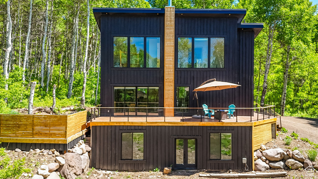 Back of property with french doors and a wooden deck