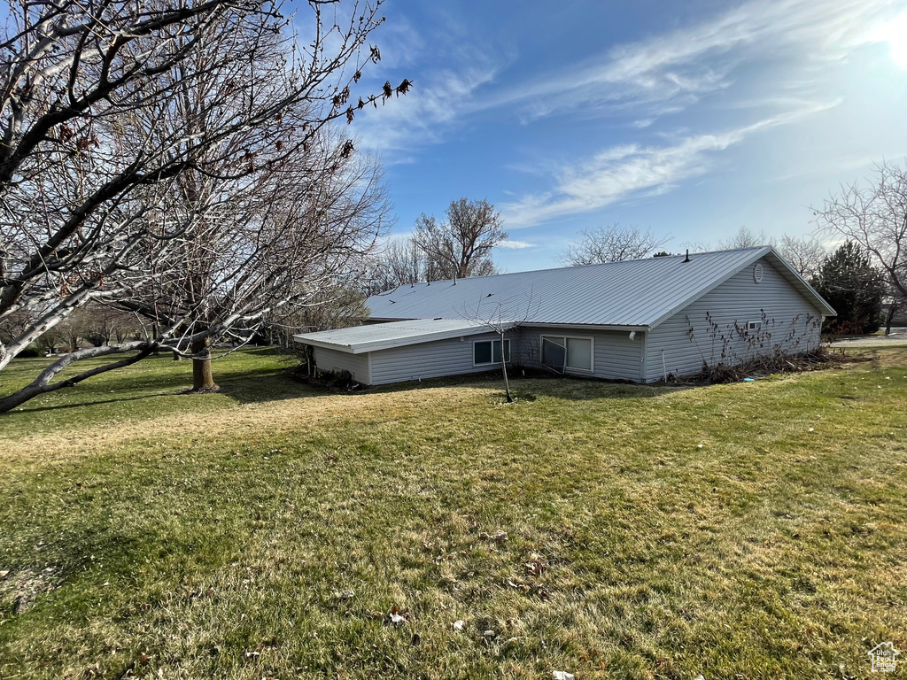 Back of property with a yard and metal roof