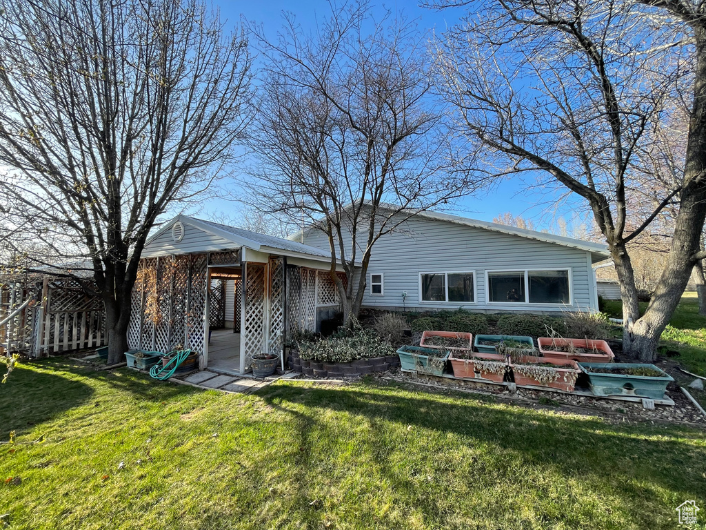 Rear view of house with a yard and a garden