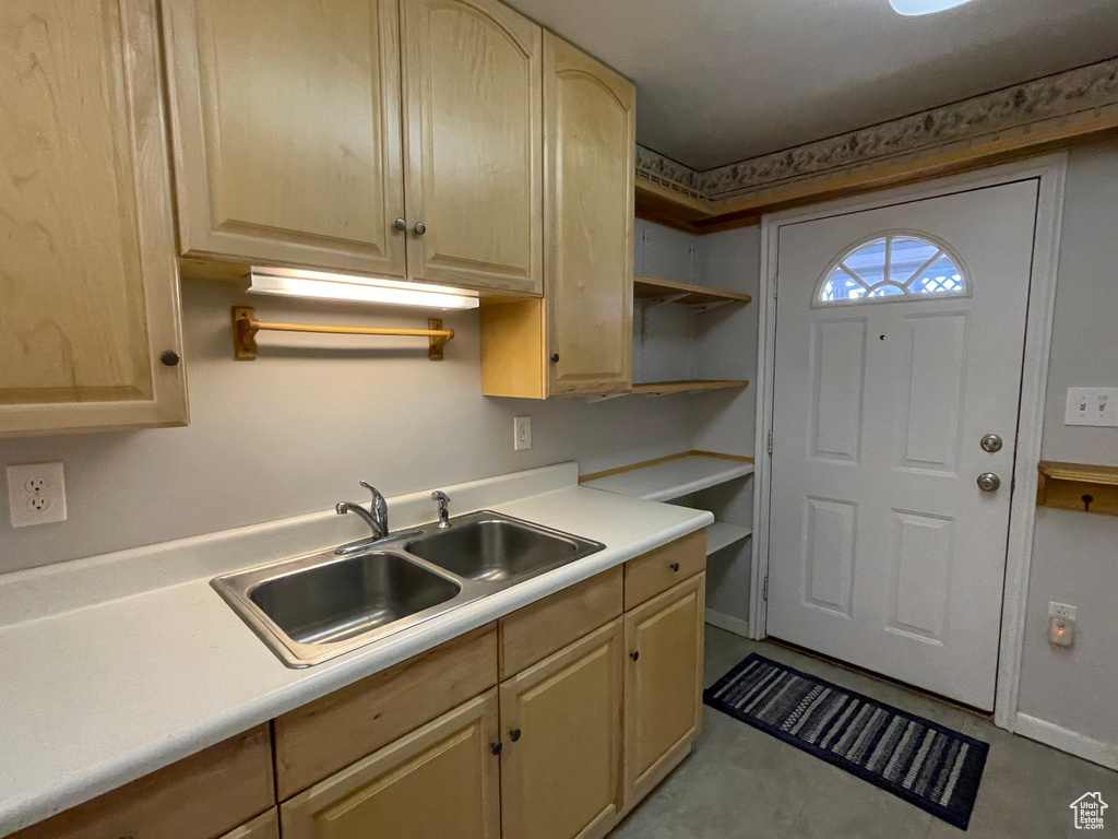 Kitchen with light brown cabinetry, light countertops, a sink, and open shelves