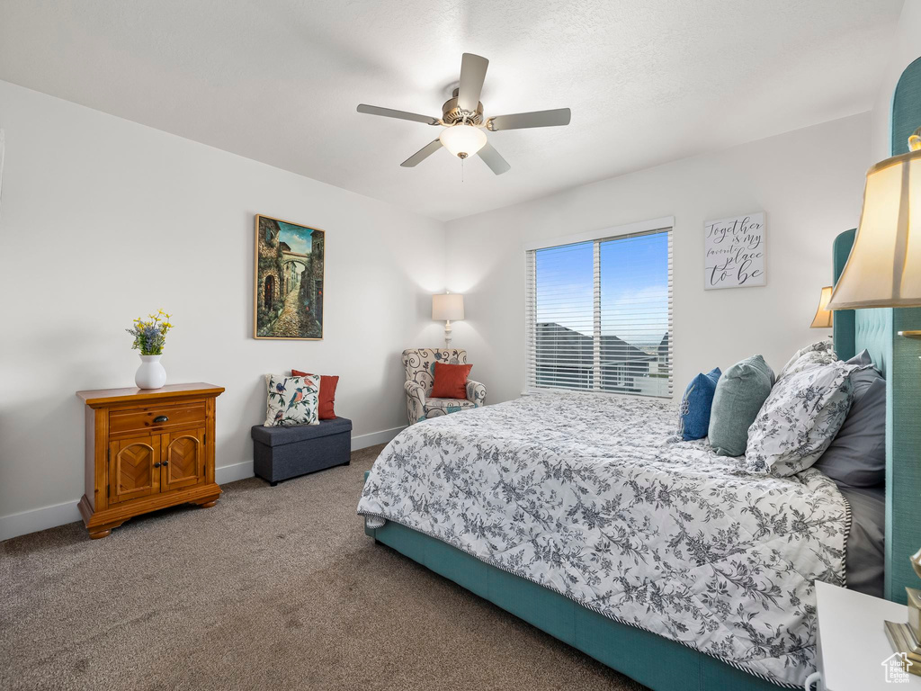 Carpeted bedroom with baseboards and a ceiling fan