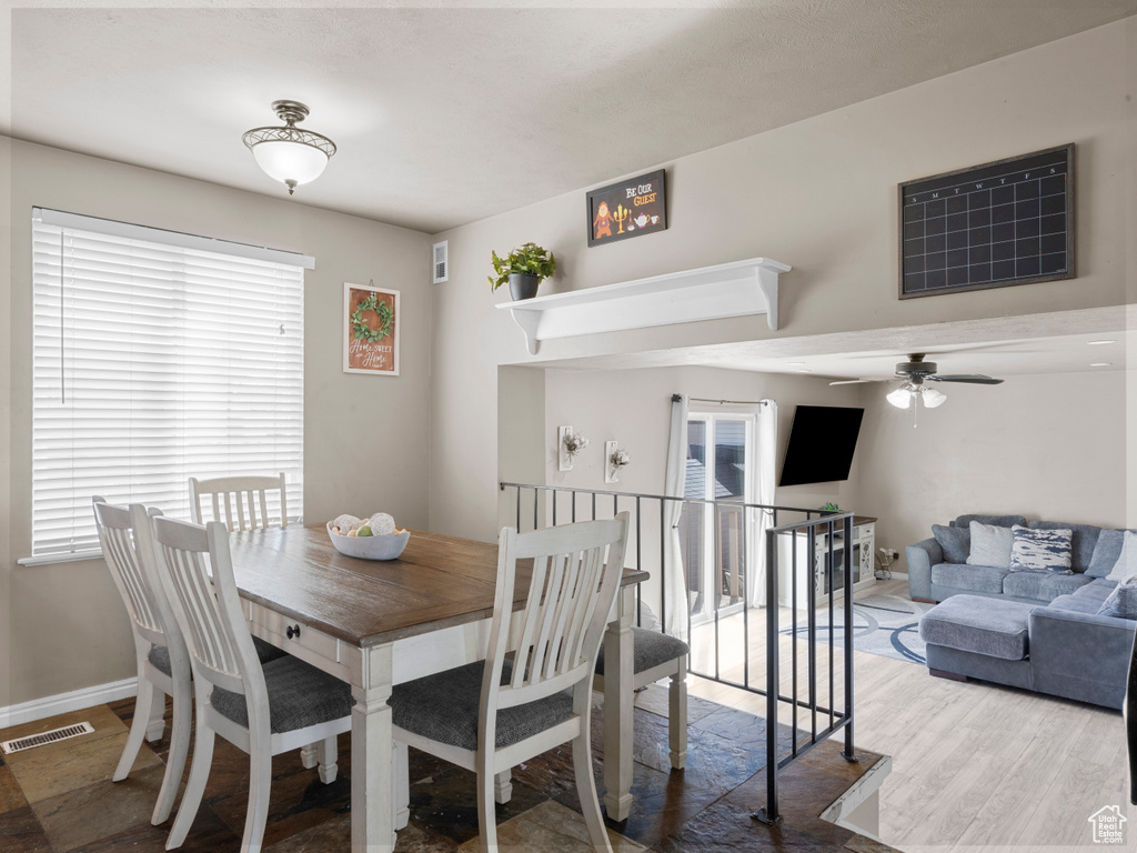 Dining space with visible vents, ceiling fan, and wood finished floors