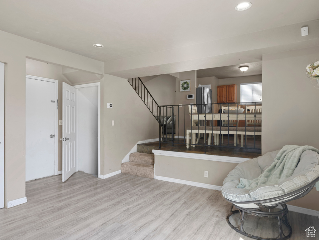 Sitting room with baseboards, recessed lighting, light wood-style floors, and stairs