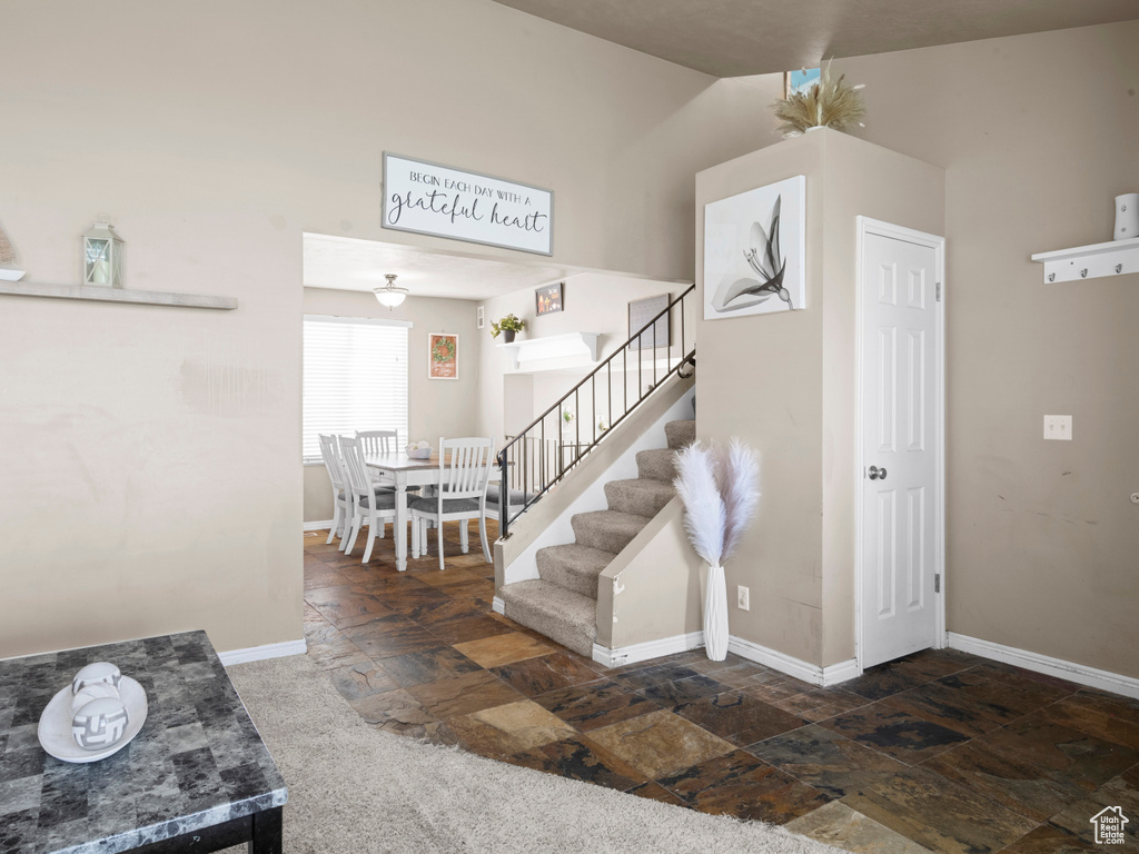 Staircase with stone tile flooring and baseboards