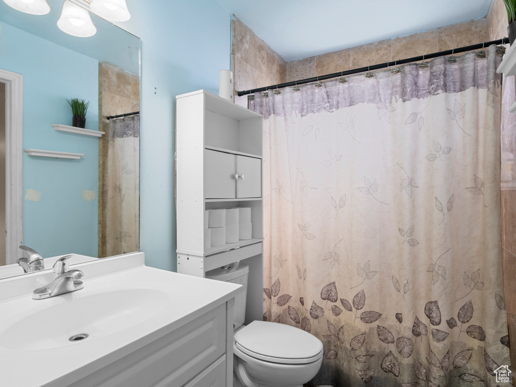 Full bath with toilet, vanity, and a shower with curtain