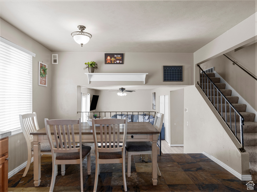 Dining space with stairway, visible vents, baseboards, and a ceiling fan