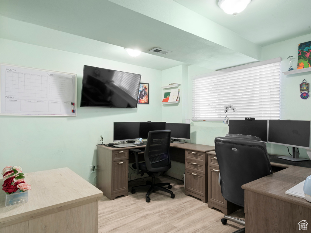 Office area featuring light wood-style floors and visible vents
