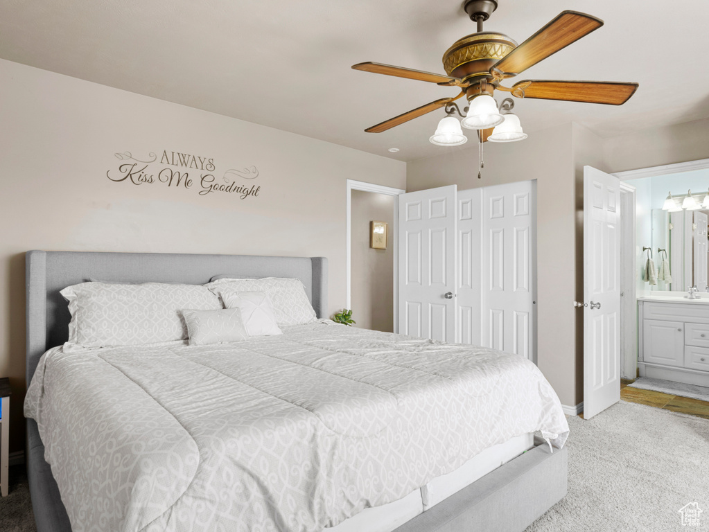 Bedroom featuring ensuite bathroom, ceiling fan, a closet, carpet floors, and baseboards