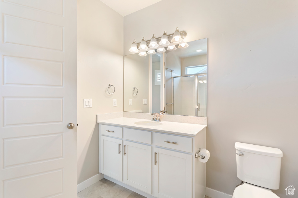 Full bath with toilet, an enclosed shower, baseboards, and vanity