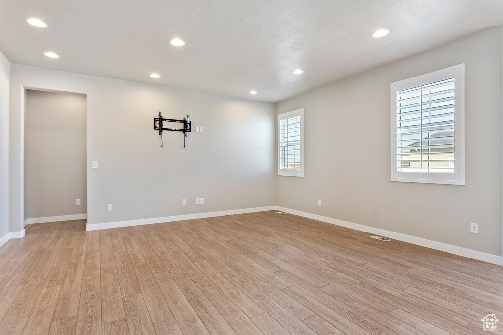 Spare room with light wood finished floors, baseboards, and recessed lighting