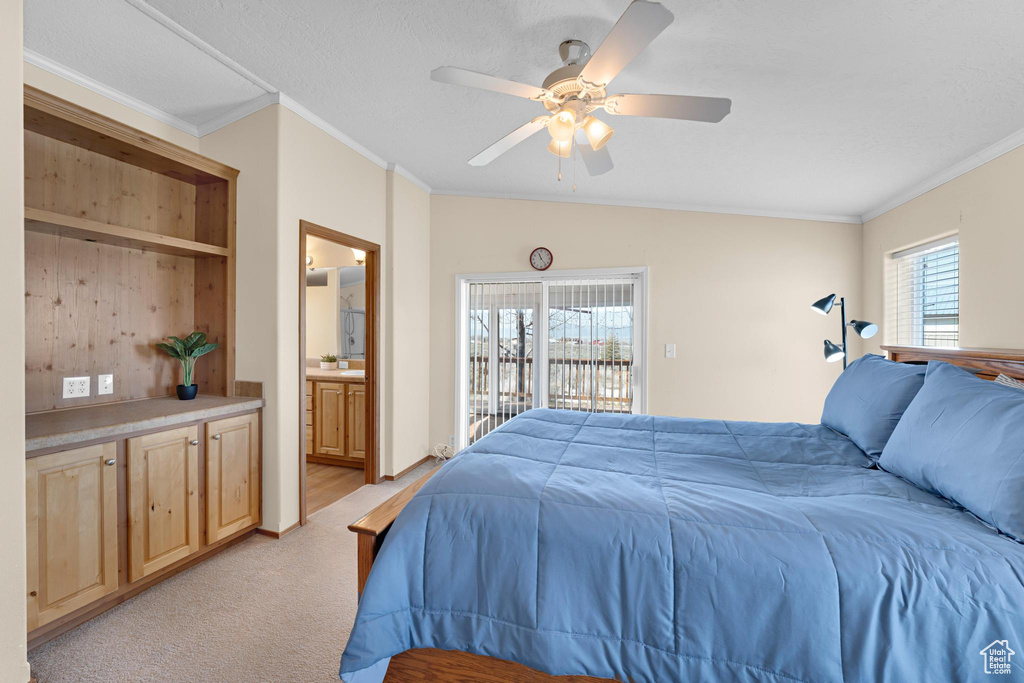 Bedroom with crown molding, ceiling fan, ensuite bathroom, light colored carpet, and access to exterior