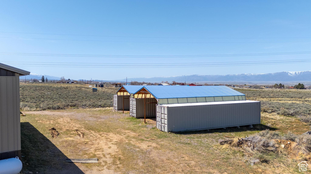 View of yard featuring a mountain view, a pole building, and an outdoor structure