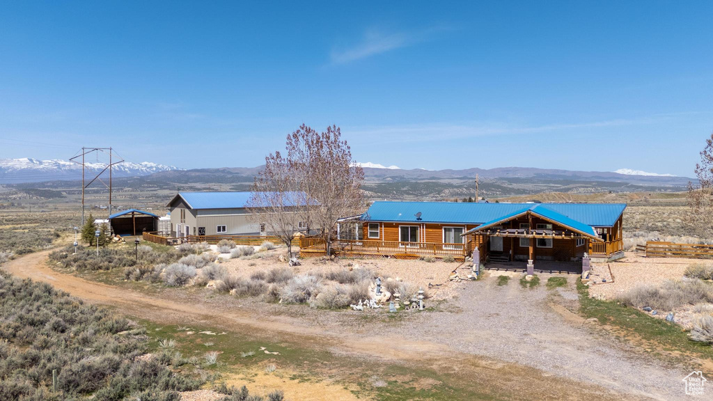 Exterior space with driveway, an outdoor structure, and a mountain view